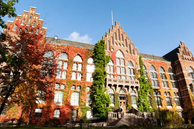 Lund University Library's greenery is in autumn colours with sun glitter in the windows. Photographer Gideon Horn.