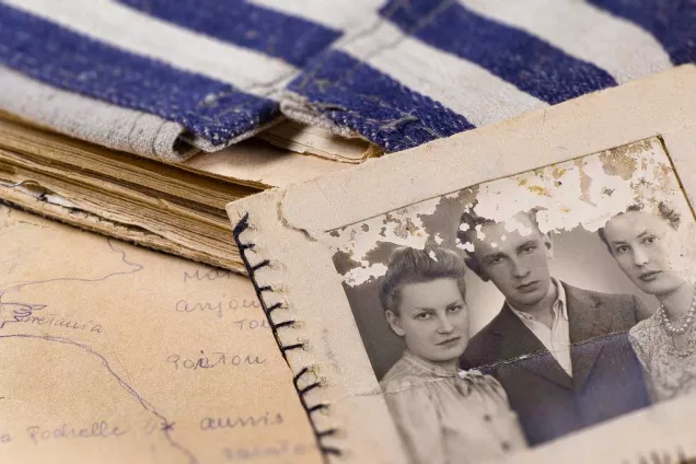 Photo of two women and a man. Handwritten notes and blue and white striped prison uniform as book cover. The photography shows material from the Ravensbrück Archive.