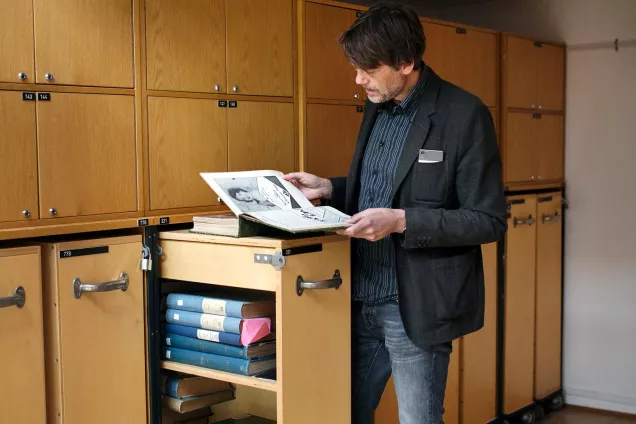 A researcher with a trolley filled with books. Photographer Johan Bävman.