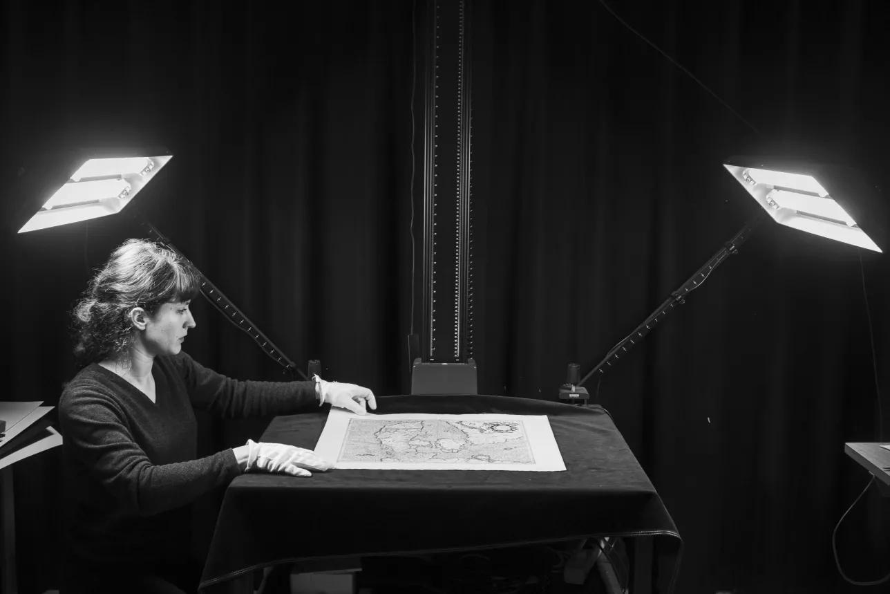 An employee is photographing a map. Photographer Johan Bävman.