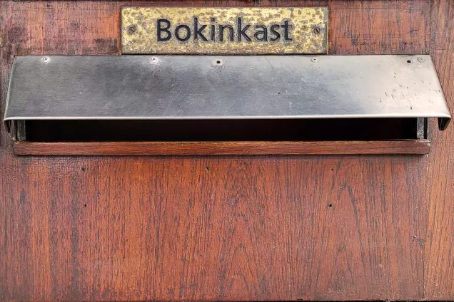 Skylt i mässing med ordet bokinkast. Foto Christel Holmberg.