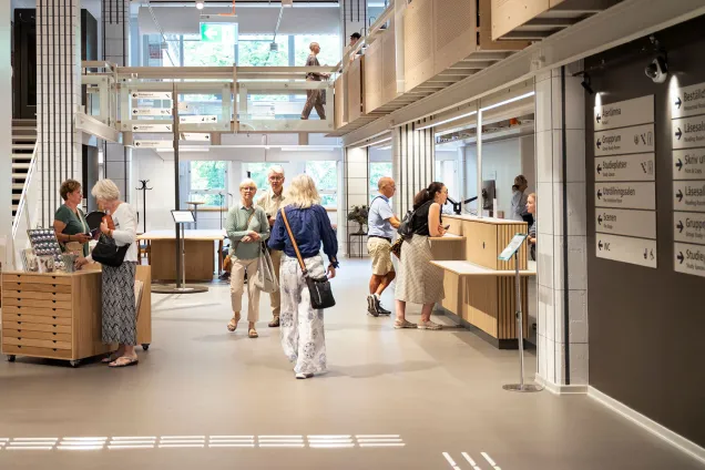 Besökare rör sig mellan rutiga pelare på entréplan.
